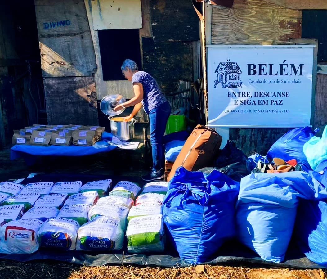 Voluntários e famílias durante distribuição de alimentos